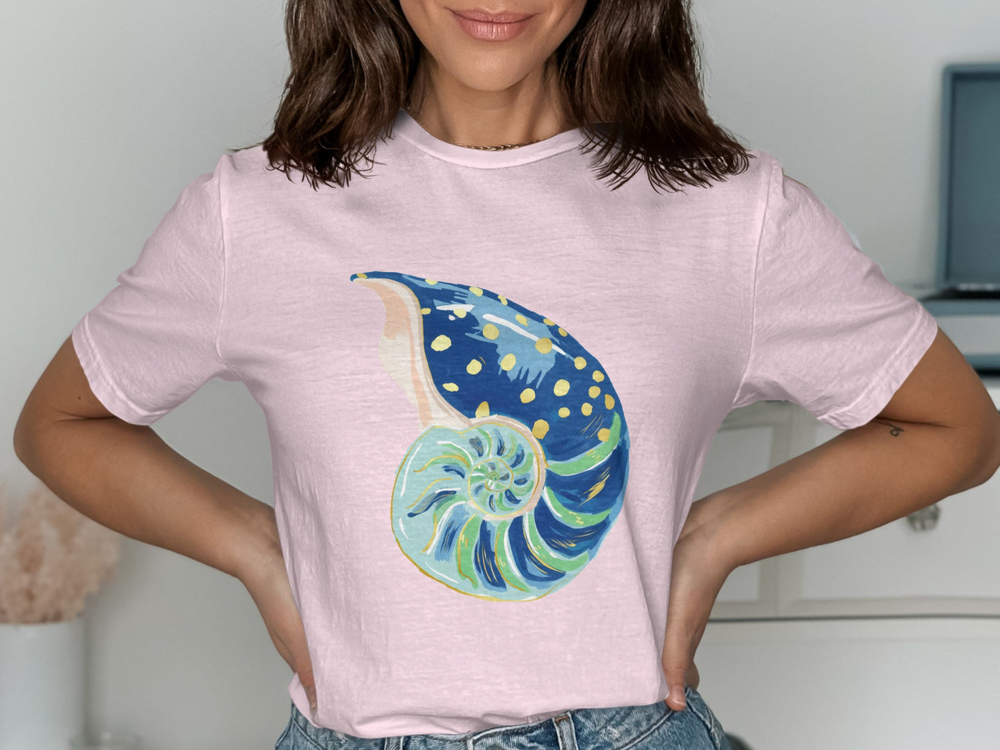 Pink t-shirt with a watercolor nautilus shell graphic.