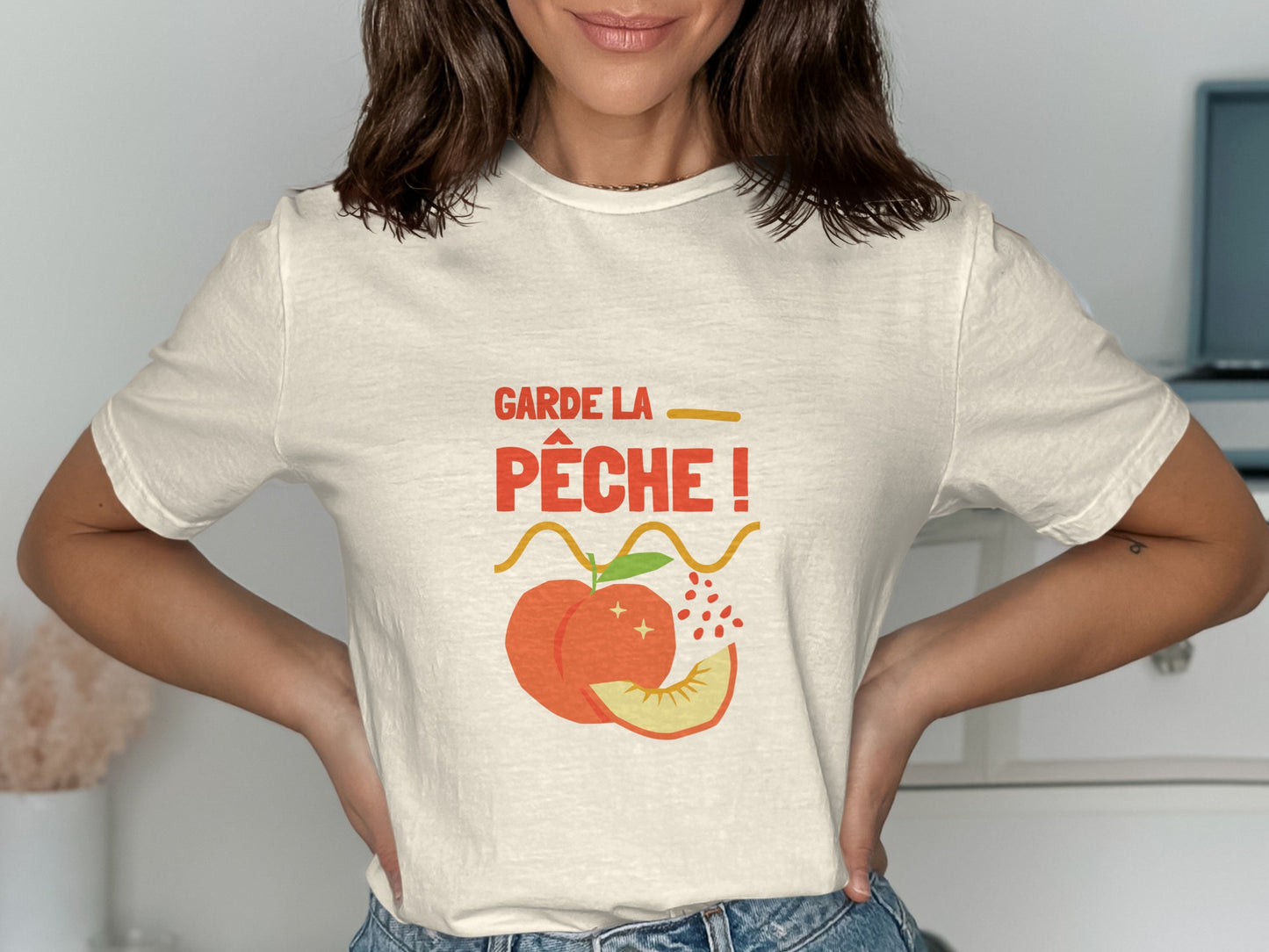 Cream t-shirt with "Garde la pêche!" text and peach graphic.