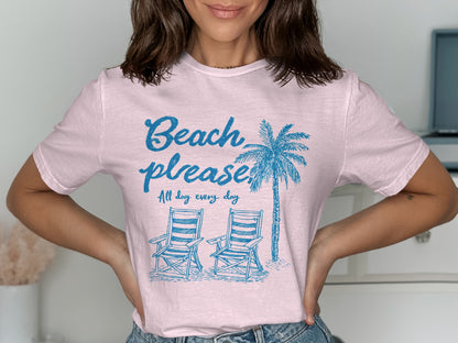 Light pink t-shirt with blue palm tree, beach chairs, and text.