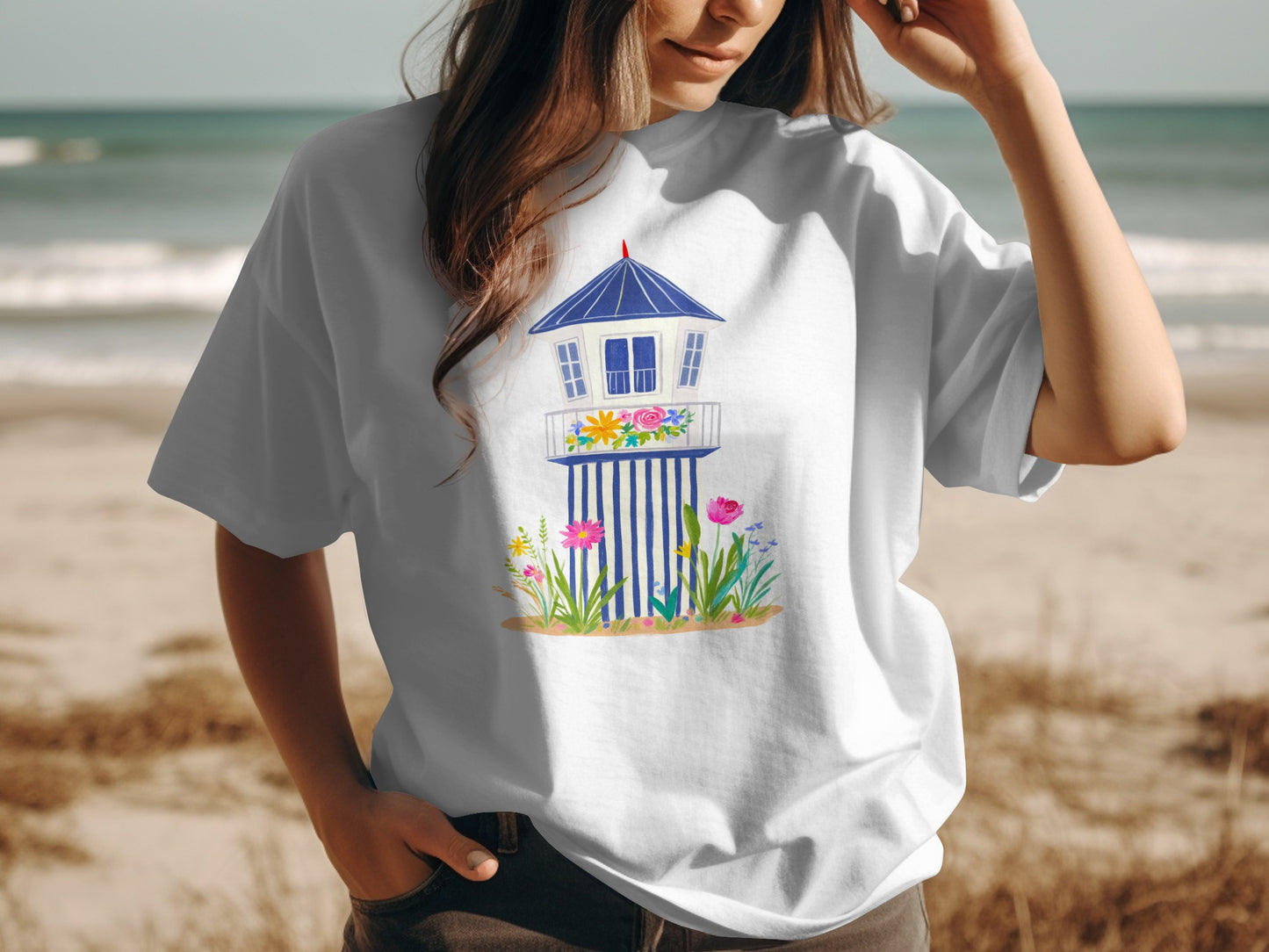 White t-shirt with a stylized lighthouse illustration and floral accents.