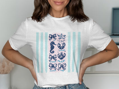 White t-shirt with blue and pink stripes featuring nautical icons: bows, seahorse, lobster, and starfish.