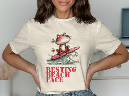 Cartoon frog surfs a wave with a butterfly, text reads "Resting Beach Face."