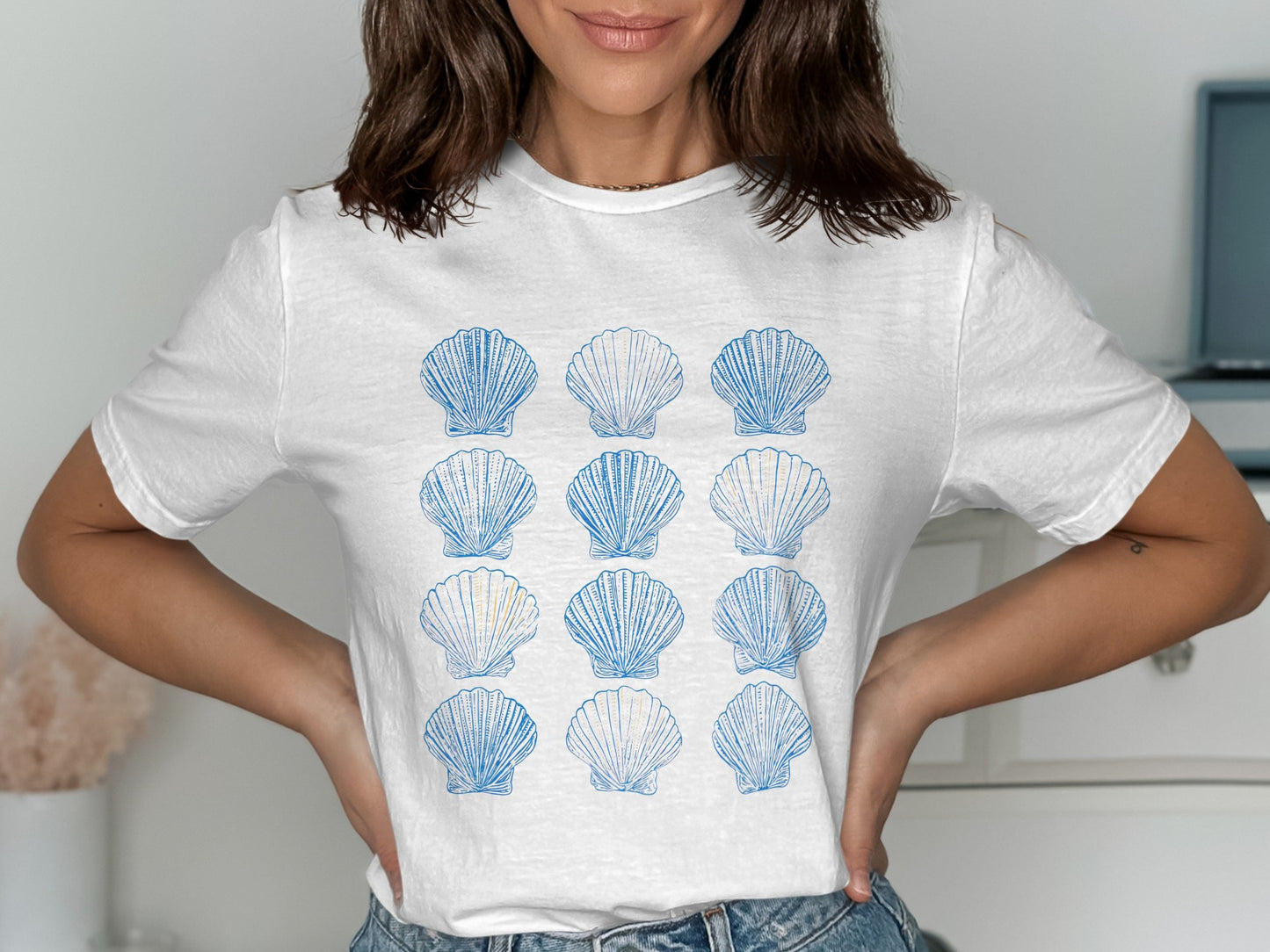 White t-shirt with a grid of blue scallop shells.