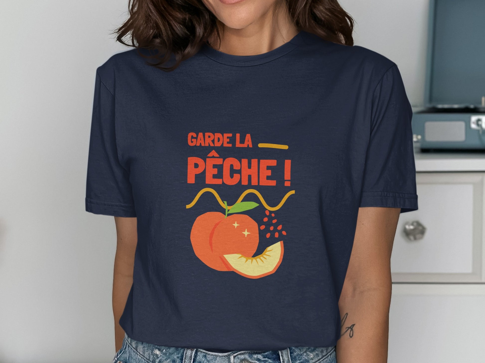 Navy t-shirt with "Garde la pêche!" slogan and peach graphic.
