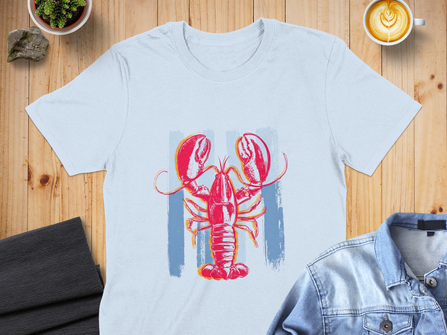 Light blue t-shirt with a red and blue abstract lobster graphic.