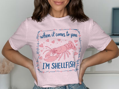 Pink t-shirt with a lobster graphic and "When it comes to you I'm Shellfish" text.