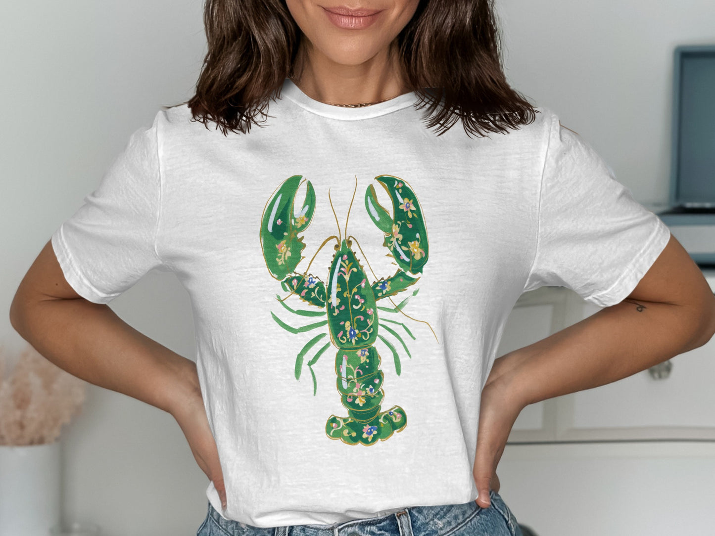 White t-shirt with a green lobster graphic featuring floral accents.