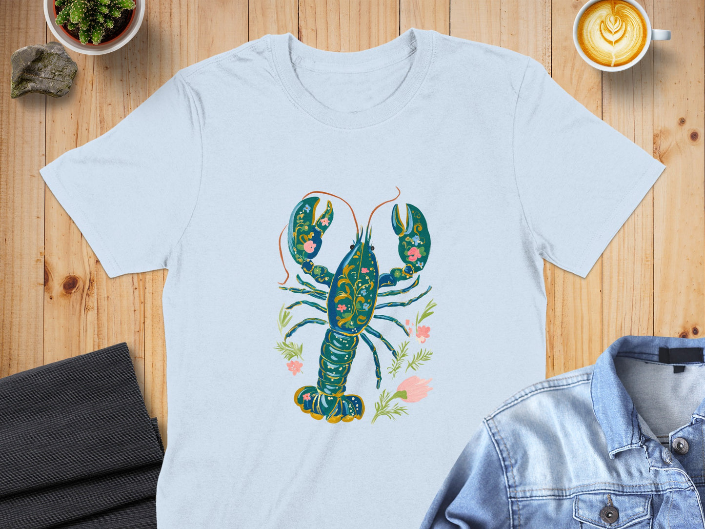 Light blue t-shirt featuring a blue and gold ornate lobster with floral accents.