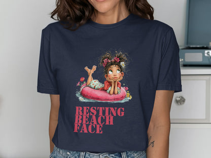 Woman in navy t-shirt with "Resting Beach Face" graphic of a girl on an inner tube.