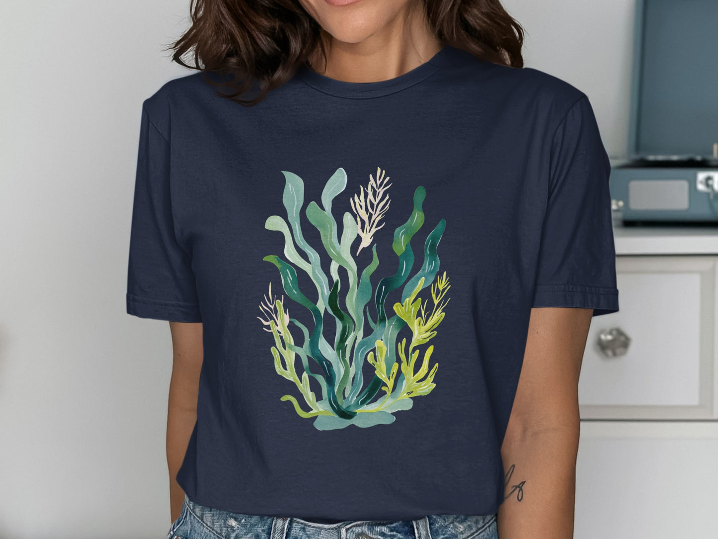 Navy t-shirt with a colorful watercolor illustration of seaweed and coral.