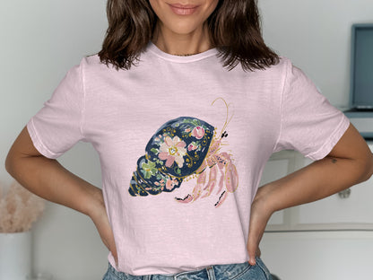 Pink t-shirt with a decorative hermit crab and floral design.
