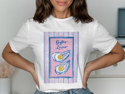 White t-shirt with a graphic of two oysters on a pink background with blue stripes.