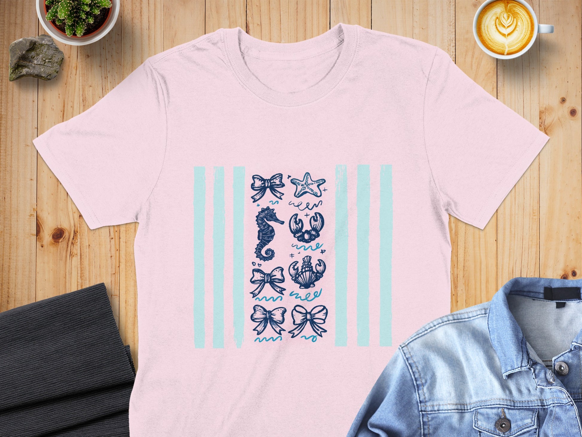Pink t-shirt with nautical illustrations on pale blue stripes.