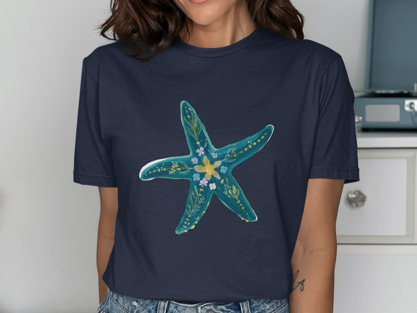 Navy t-shirt with a teal starfish design and floral accents.