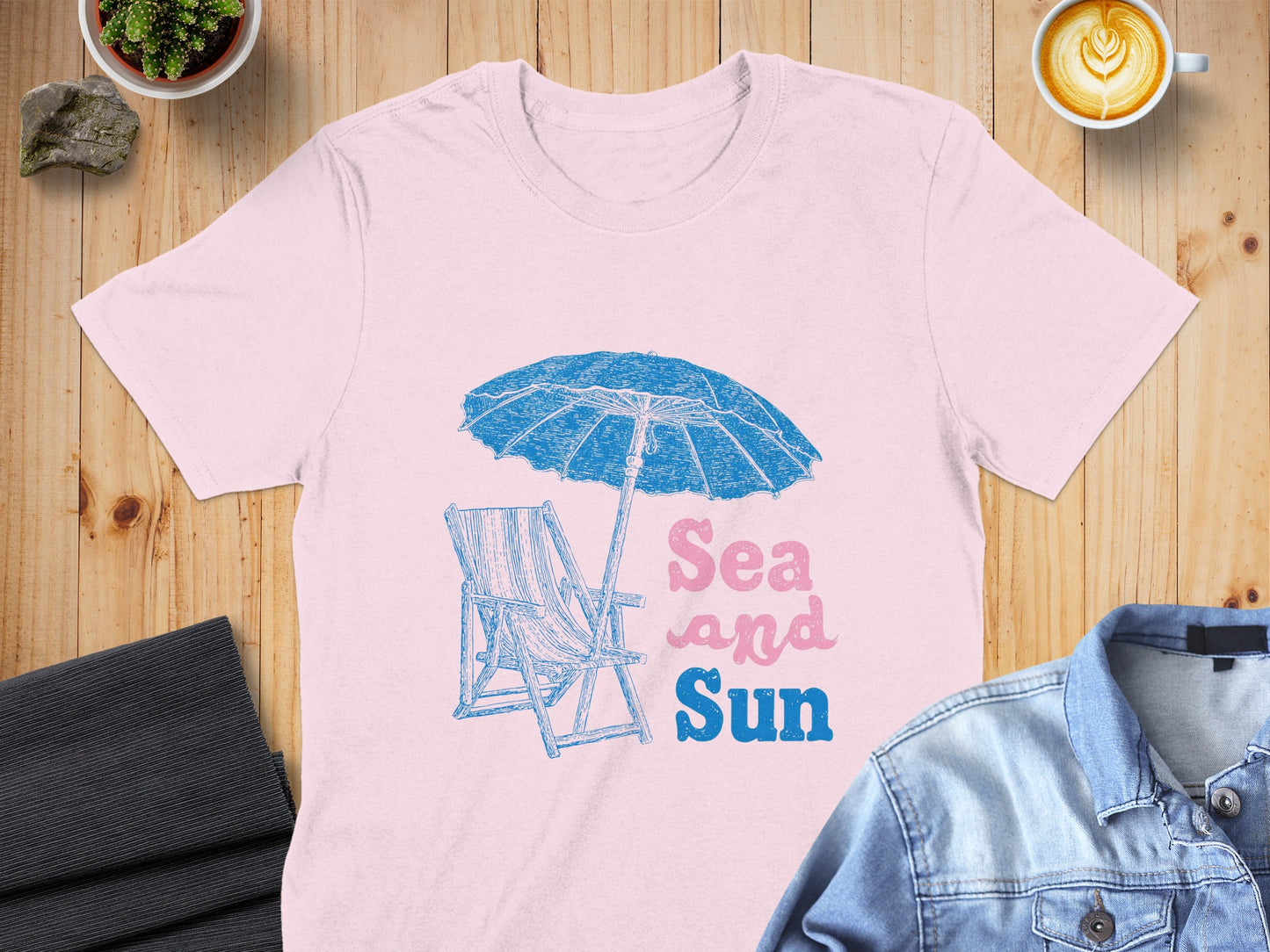 Pink t-shirt with beach chair, umbrella, and "Sea and Sun" text.