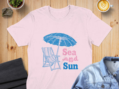 Pink t-shirt with beach chair, umbrella, and "Sea and Sun" text.