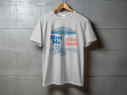 White t-shirt with "Meet Me At The Beach" text and beach umbrella illustration.