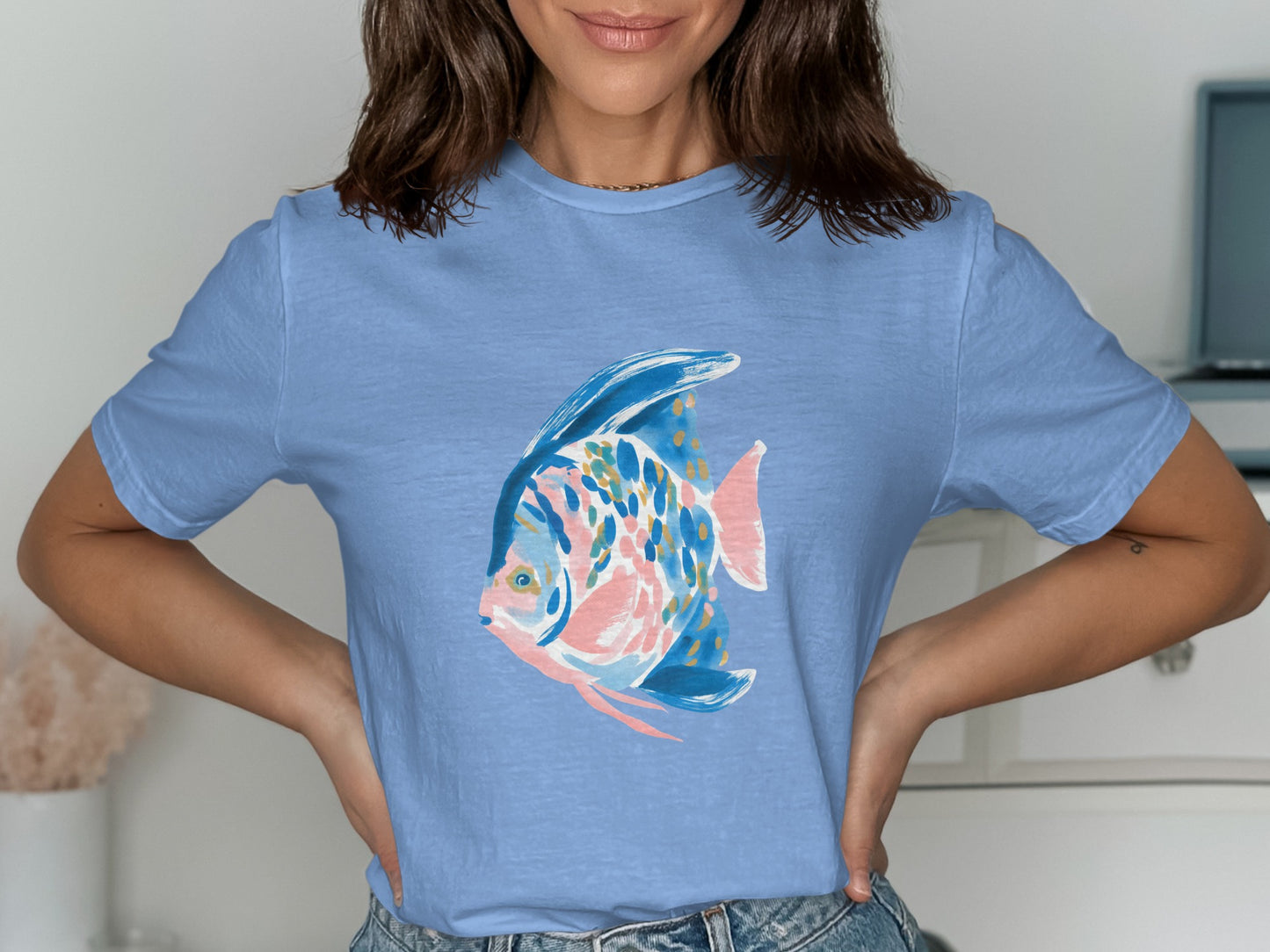 Light blue t-shirt with a stylized blue, pink, and gold fish graphic.