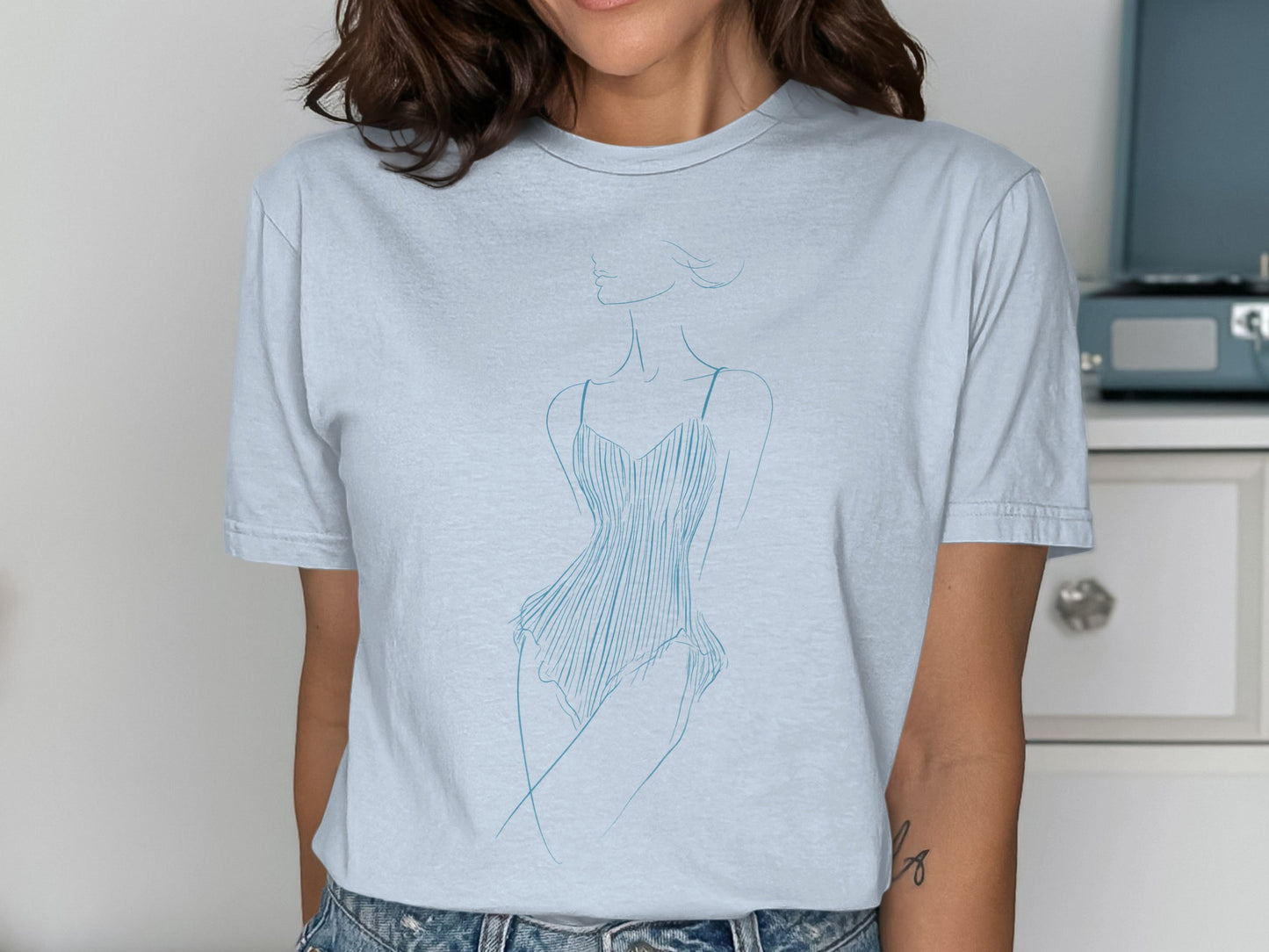 Light blue t-shirt with a minimalist line drawing of a woman in a corset.