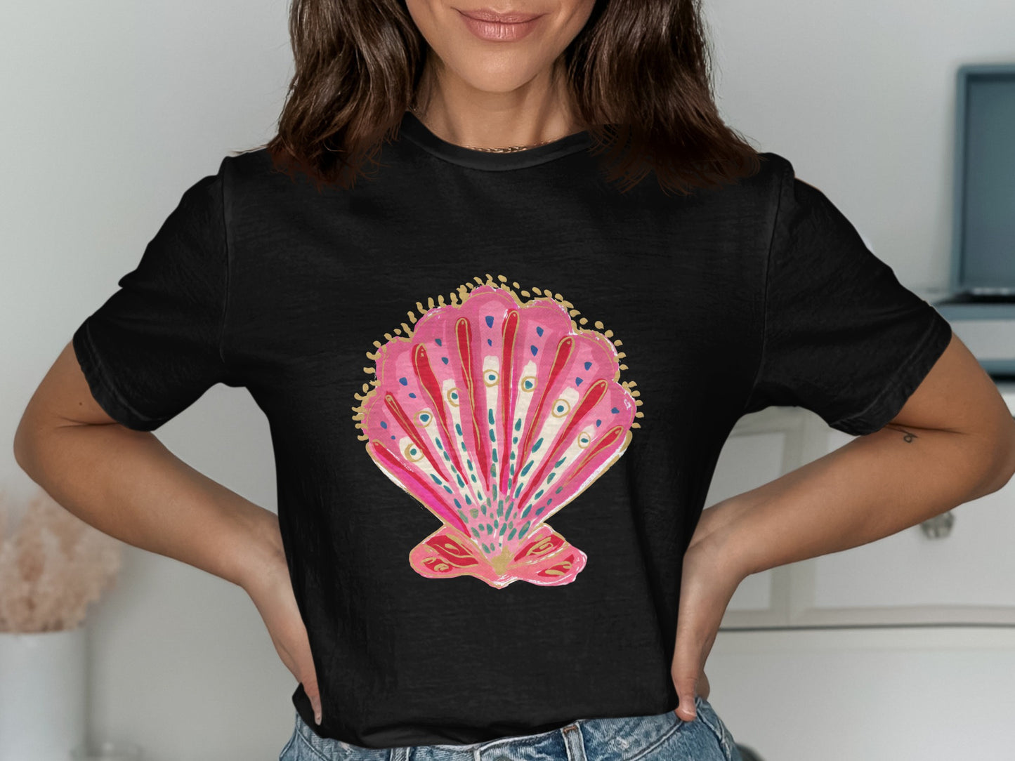 Black t-shirt with a pink seashell graphic featuring gold and blue accents.