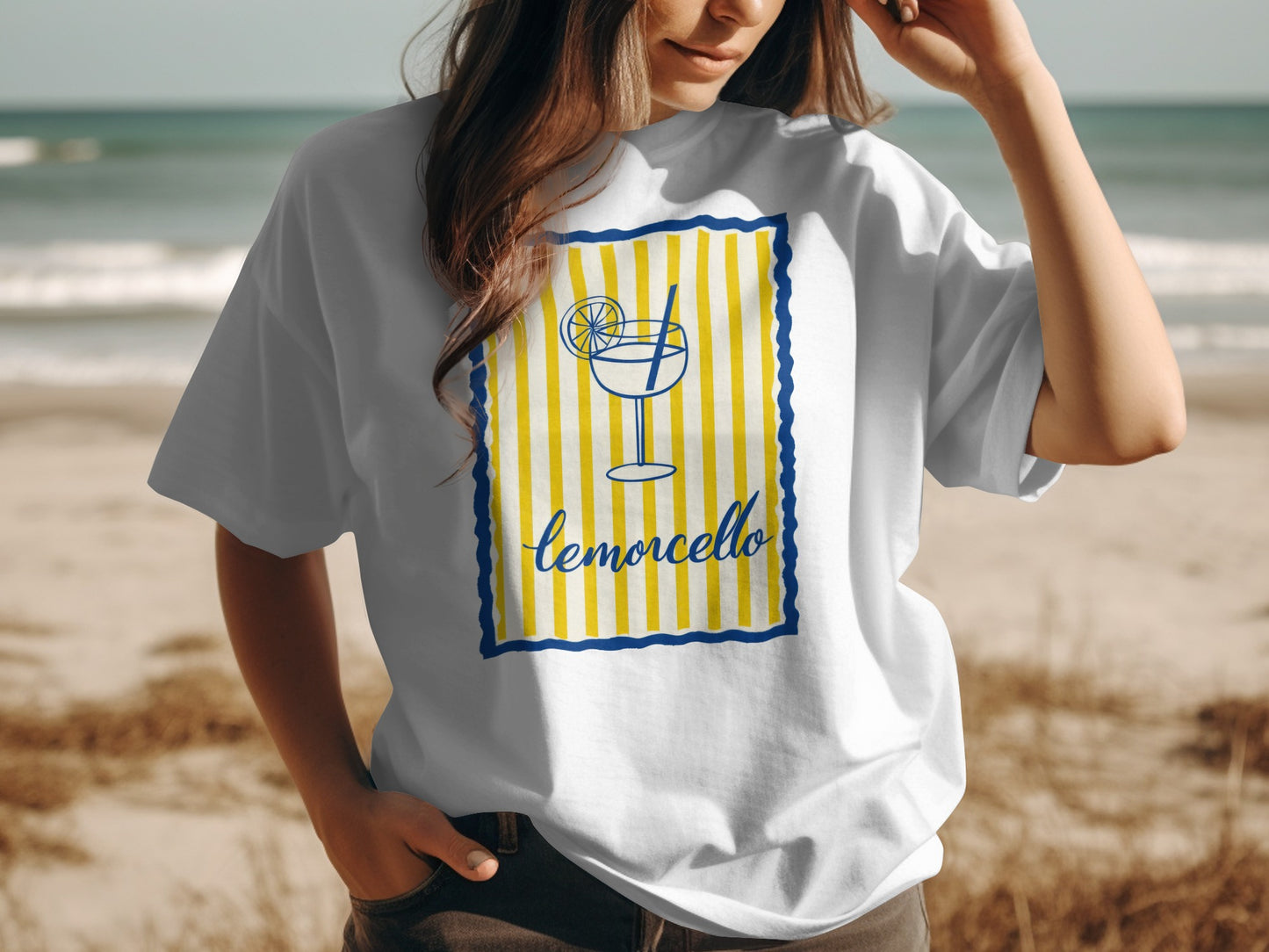 White t-shirt with a yellow and blue striped limoncello graphic and straw.
