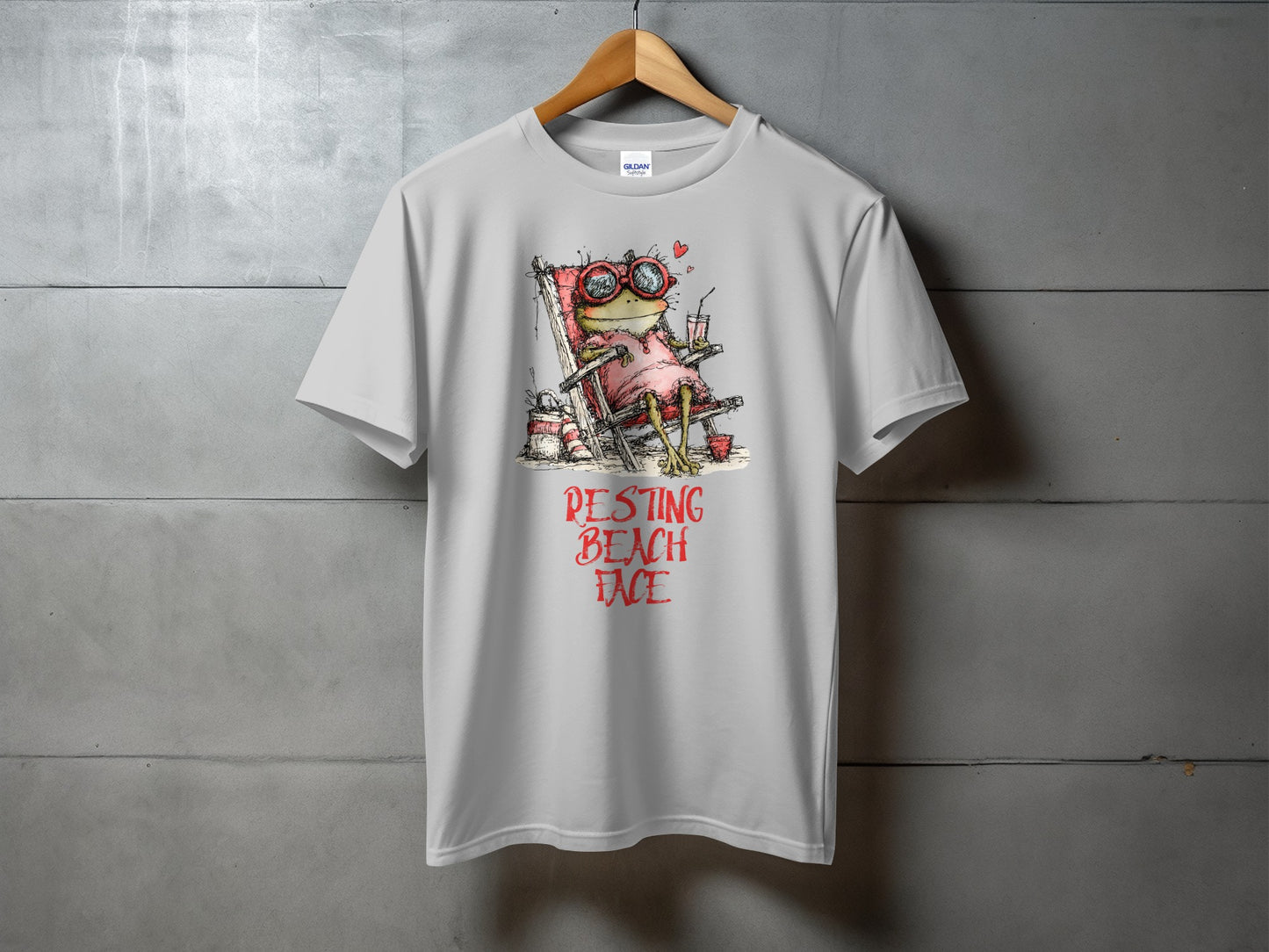 Grey t-shirt with a cartoon frog in sunglasses relaxing in a beach chair.