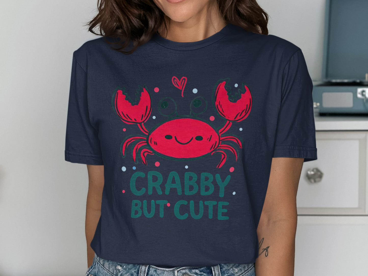 Navy t-shirt with a smiling cartoon crab and "CRABBY. BUT CUTE" text.