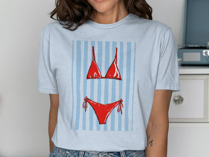 Light blue t-shirt with a red bikini graphic on a striped background.