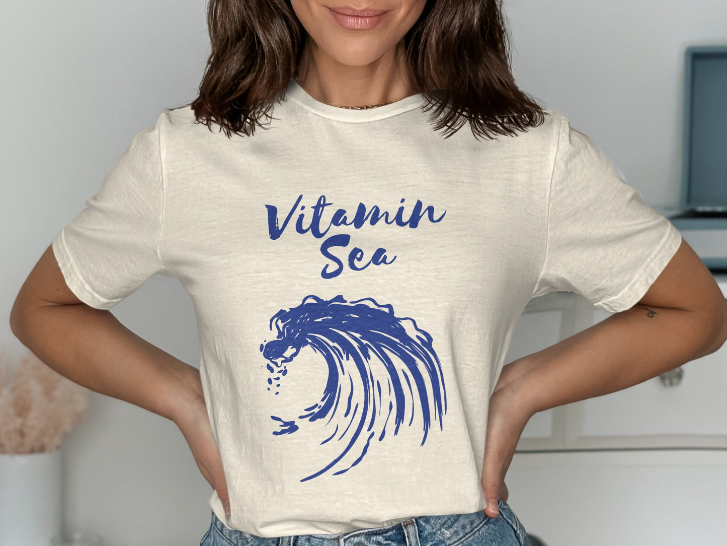 Cream t-shirt with blue "Vitamin Sea" text and a crashing wave graphic.