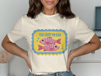 Cream t-shirt with a yellow and blue framed graphic featuring two pink fish and text.