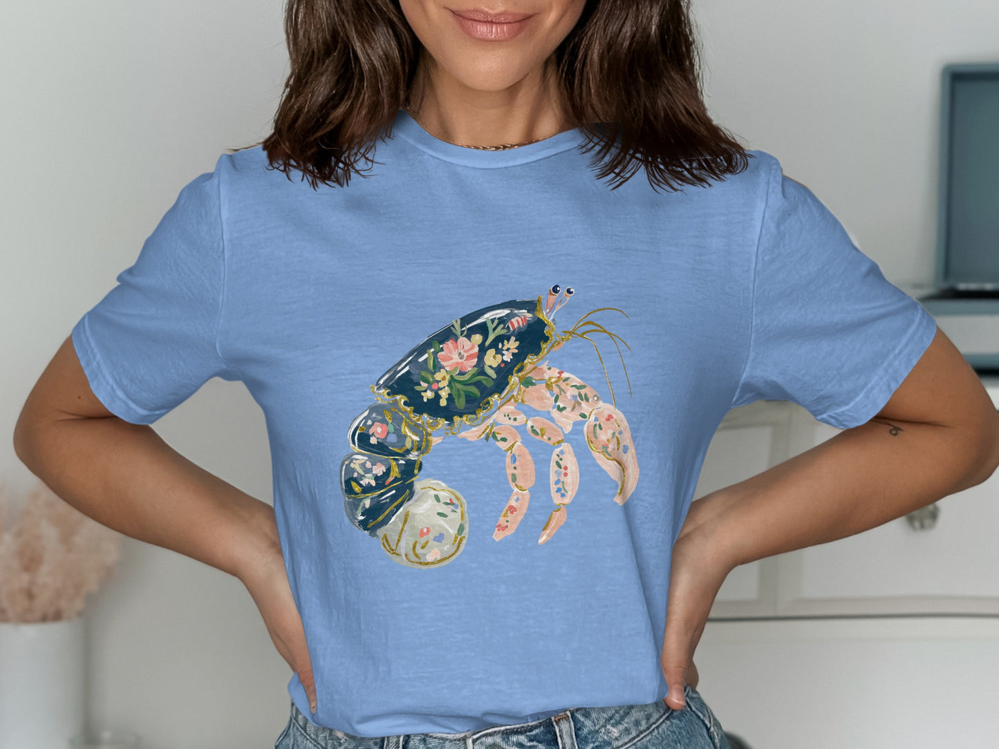Light blue t-shirt featuring a decorative hermit crab with floral patterns.