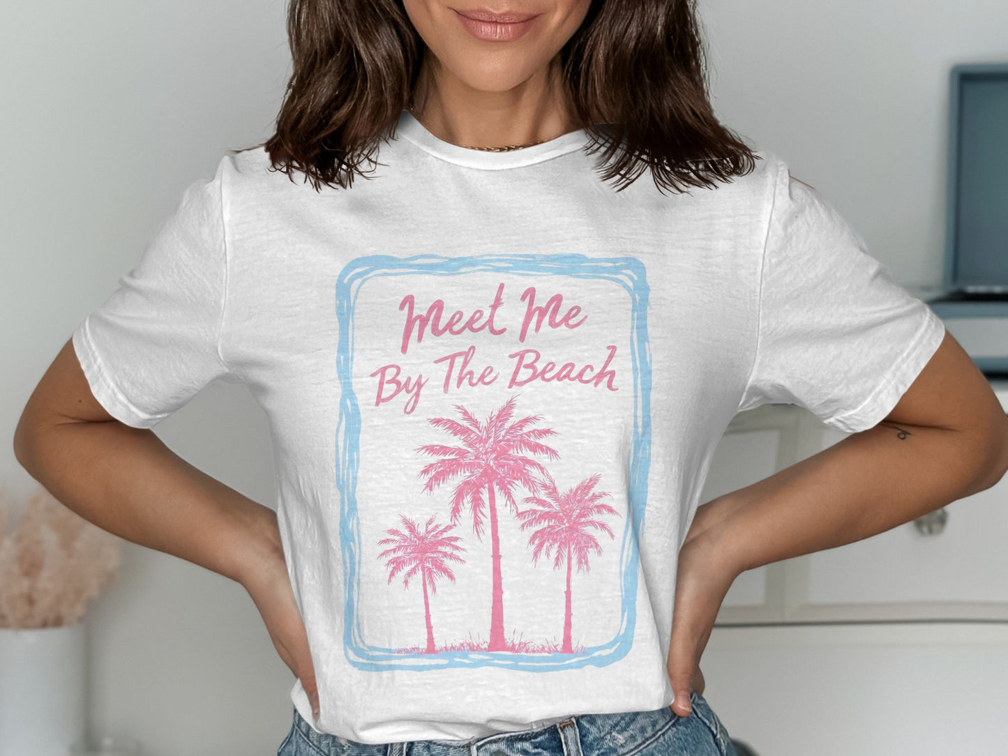 White t-shirt with pink palm trees and "Meet Me By The Beach" text.