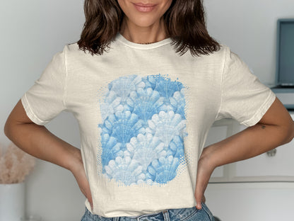 Cream t-shirt with a watercolor print of blue seashells.