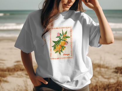 White t-shirt with orange branch graphic and "Orange" text on a beach.