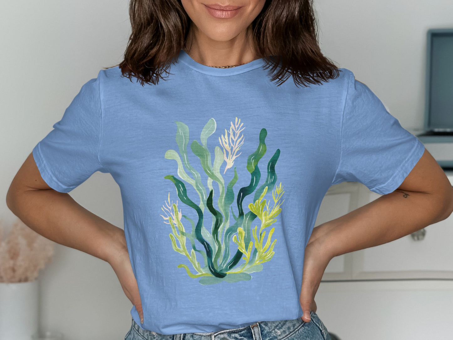 Light blue t-shirt with a watercolor illustration of green and yellow seaweed.