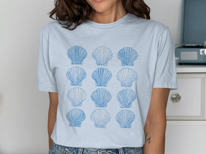 Light blue t-shirt with a repeating pattern of blue scallop shells.