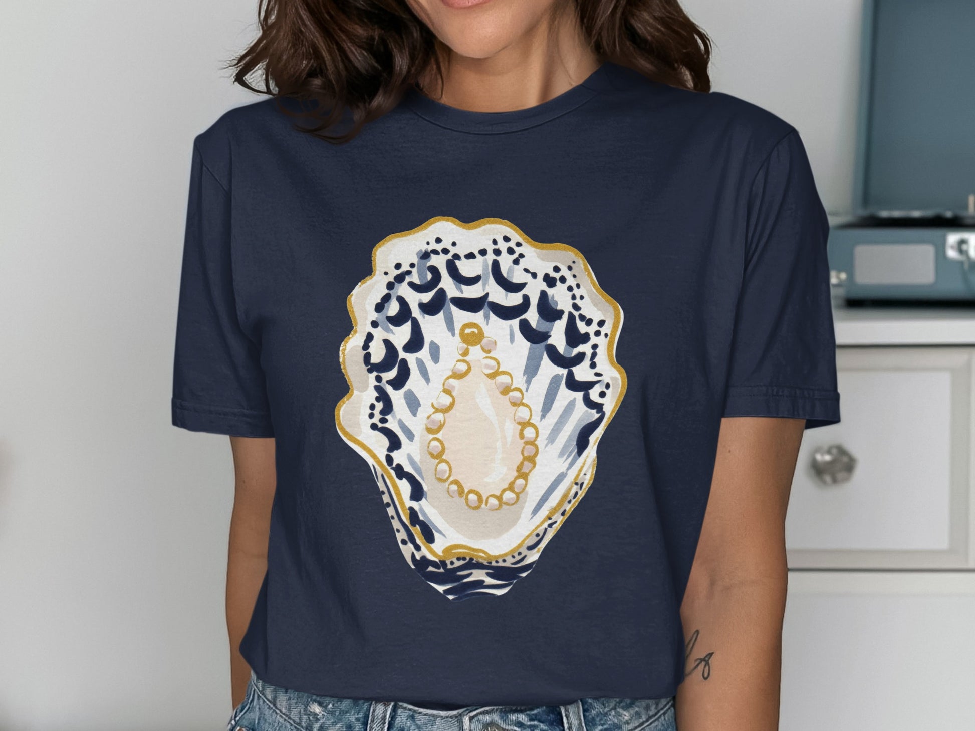 Navy t-shirt with a watercolor oyster and pearl graphic.