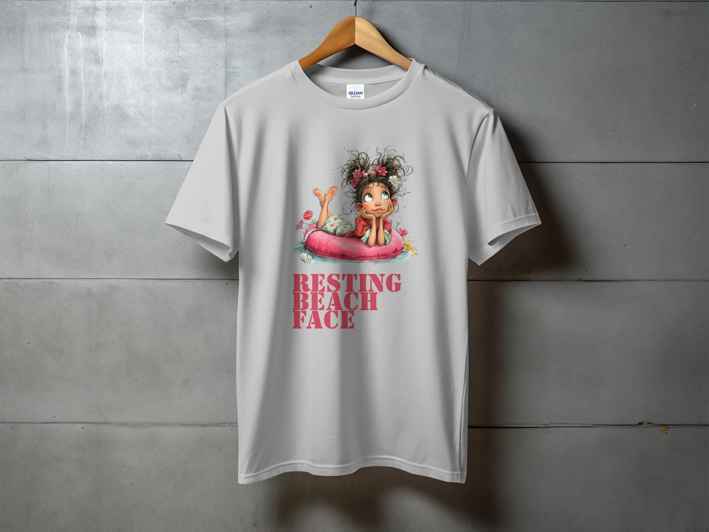 White t-shirt with graphic of a girl on an inflatable ring, "RESTING BEACH FACE" text.