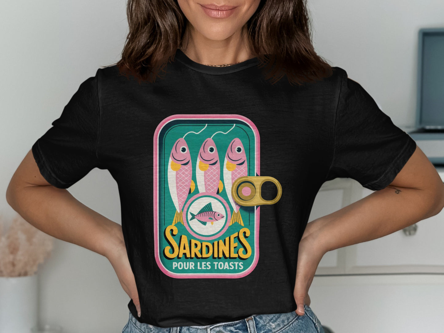 Black t-shirt featuring a vintage sardine can label with three pink fish.