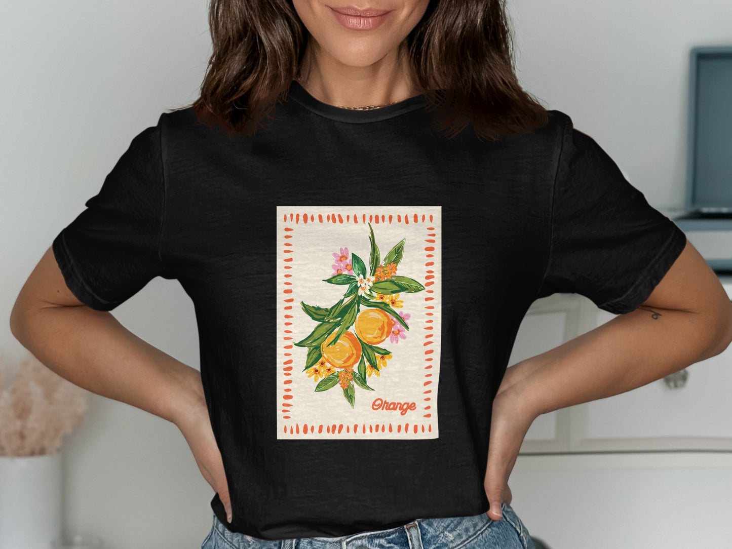 Black t-shirt featuring a graphic of an orange branch with blossoms and text.