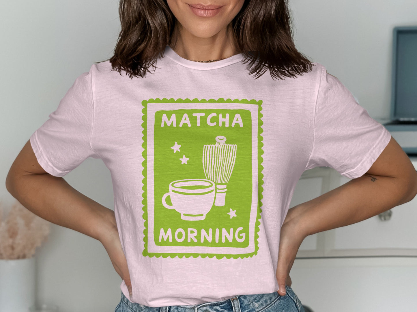 Pink t-shirt with a green graphic of a matcha cup and whisk.