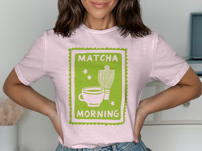Pink t-shirt with a green graphic of a matcha cup and whisk.