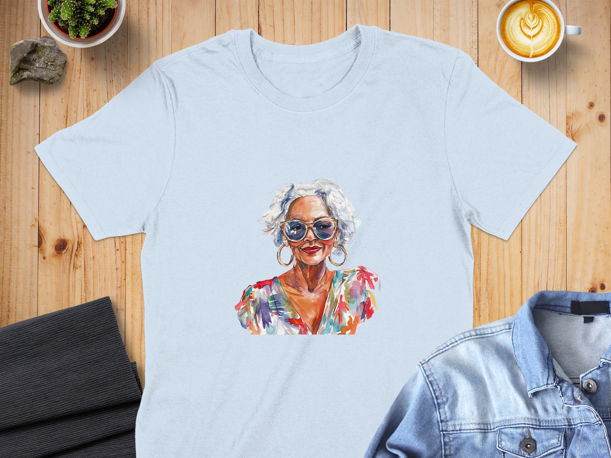 Watercolor portrait of a woman with white hair and sunglasses on a light blue t-shirt.