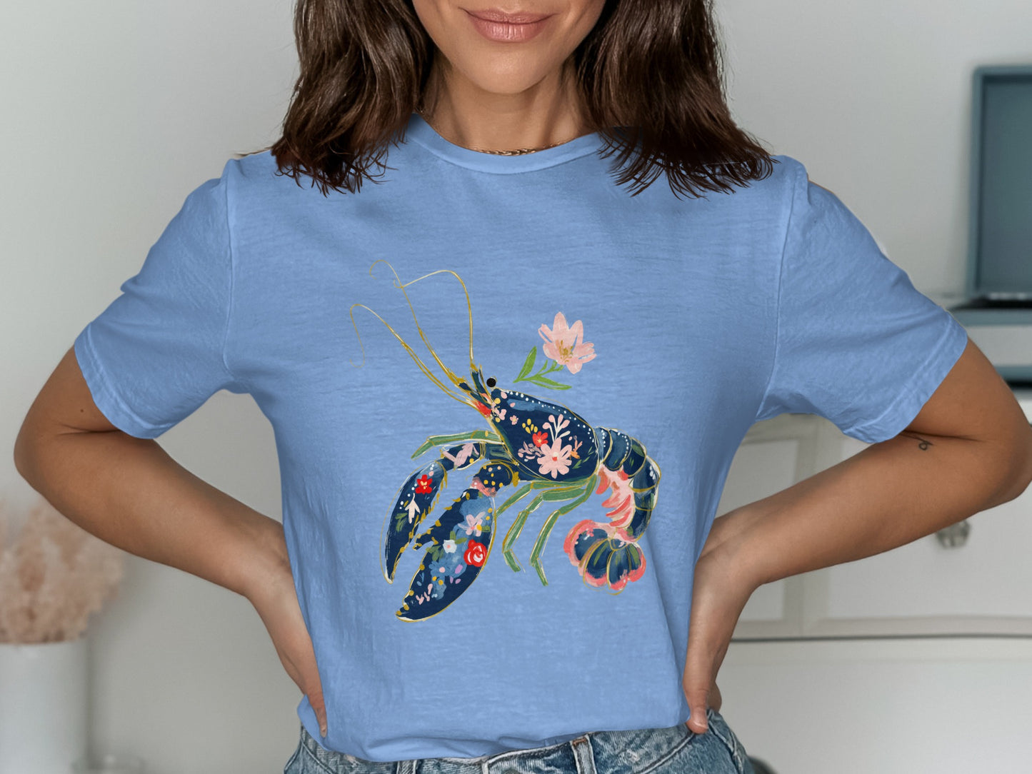 Blue t-shirt with a navy lobster graphic filled with colorful flowers.