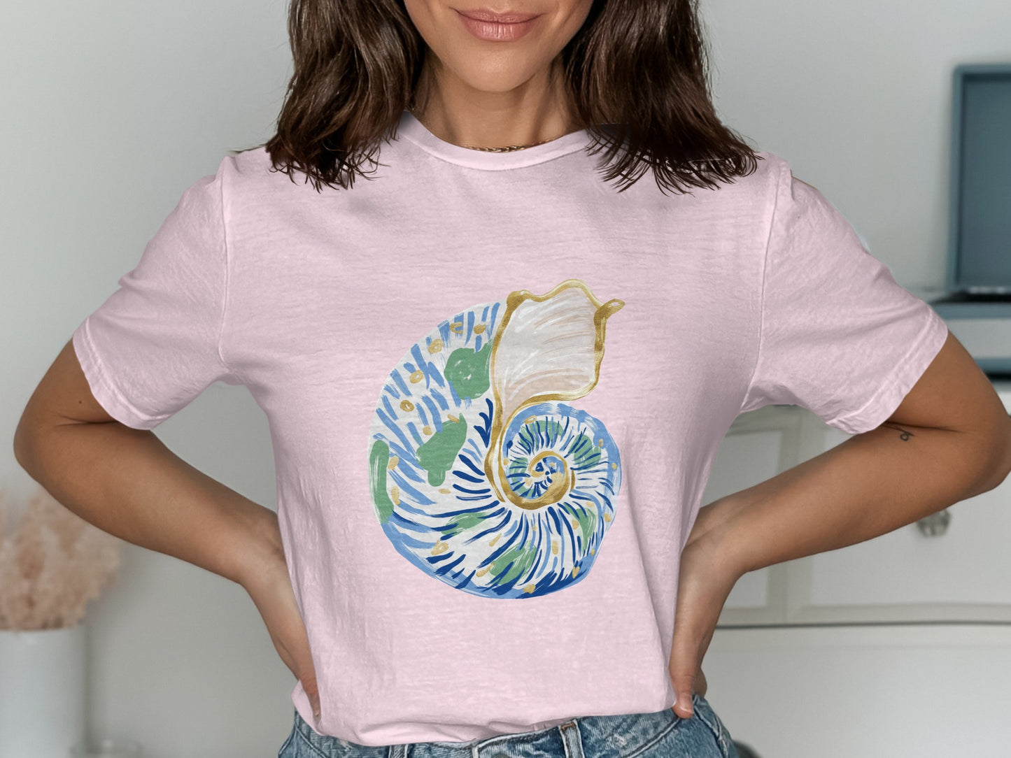 Pink t-shirt with watercolor nautilus shell design.