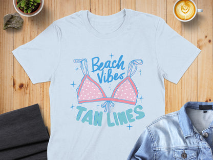 Light blue t-shirt with pink polka dot bikini top graphic and "Beach Vibes Tan Lines" text.