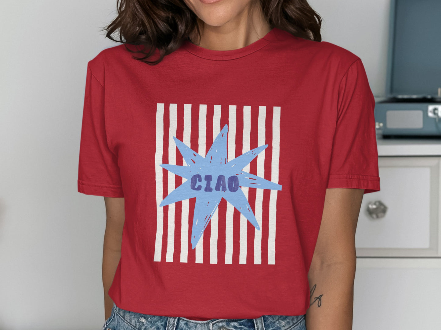 Red t-shirt with blue "Ciao" text and white stripes on a starburst.