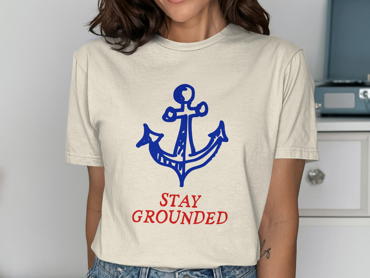 Cream t-shirt with blue anchor graphic and red "STAY GROUNDED" text.