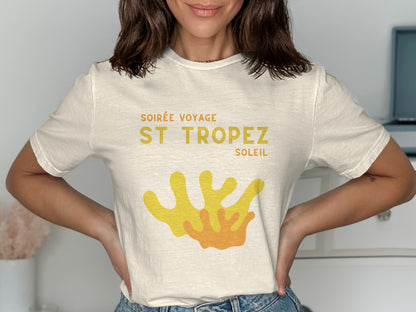 Cream t-shirt with "Soirée Voyage St. Tropez Soleil" text and orange and yellow coral graphic.