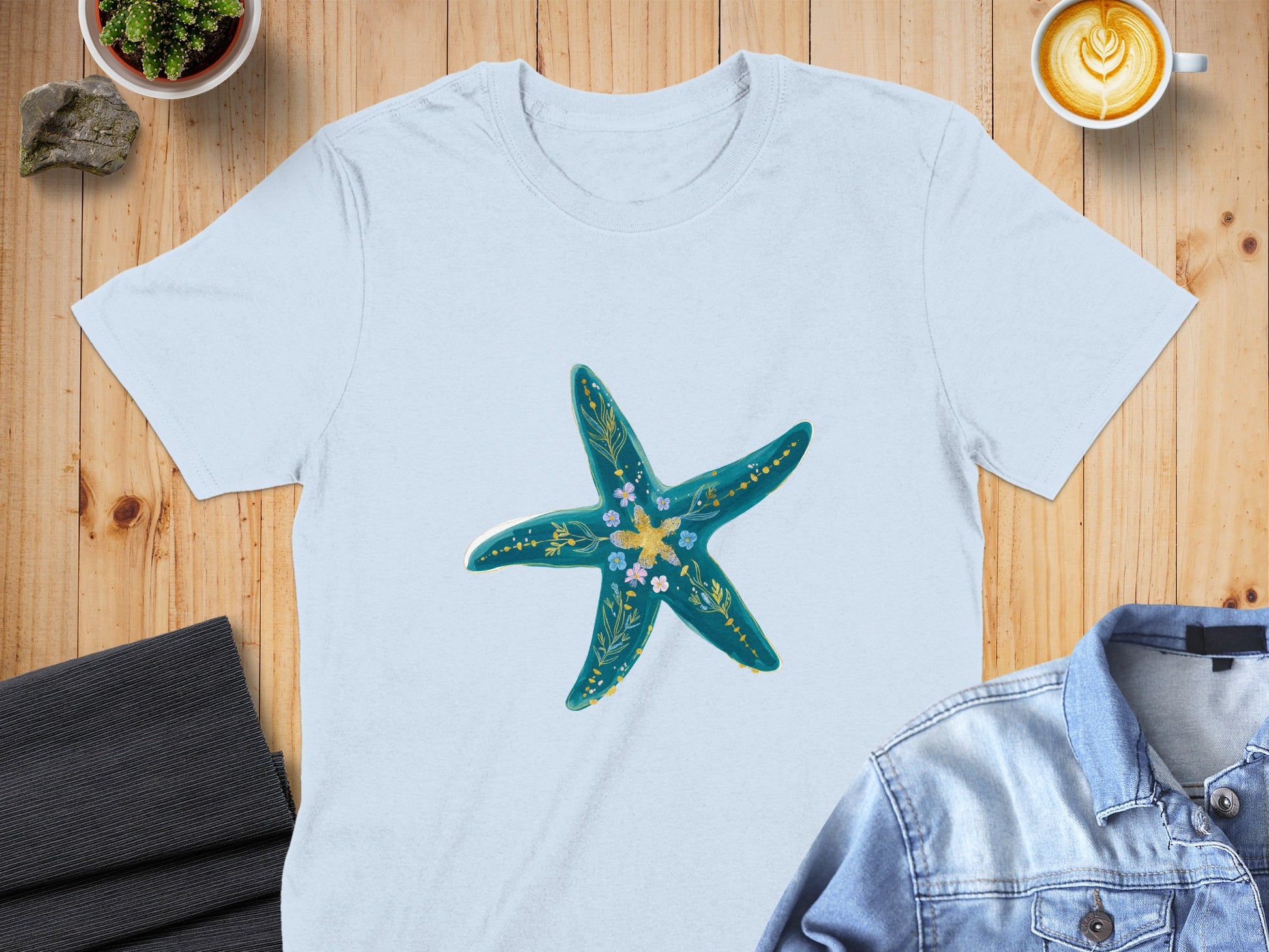 Light blue t-shirt with a teal starfish graphic featuring yellow and blue floral accents.